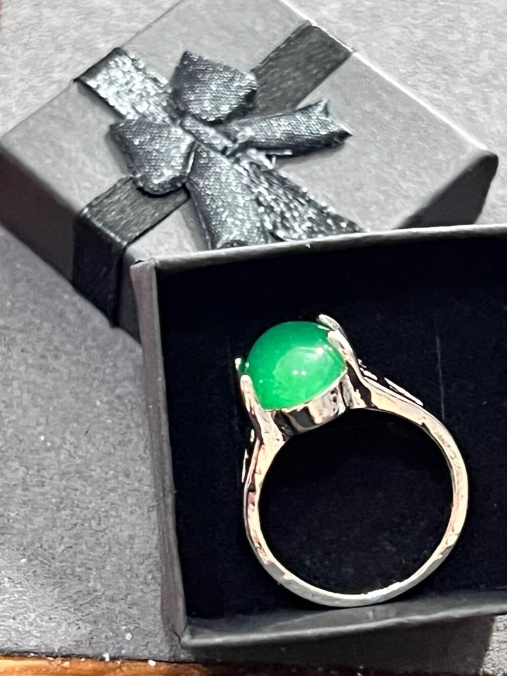 Elegant silver\-tone ring featuring oval bright green cabochon stone with decor